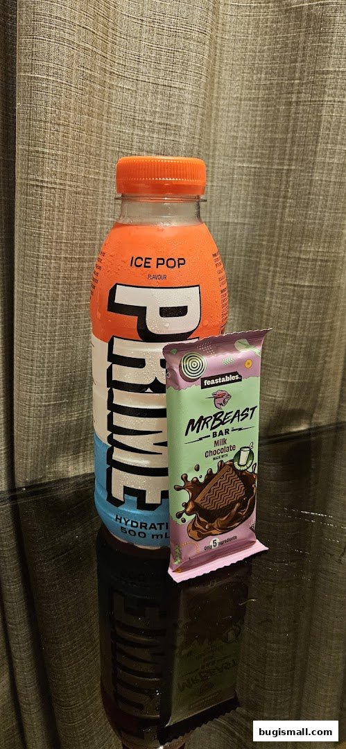 A bottle of Prime Hydration 'Ice Pop' flavor next to a MrBeast Milk Chocolate bar.
