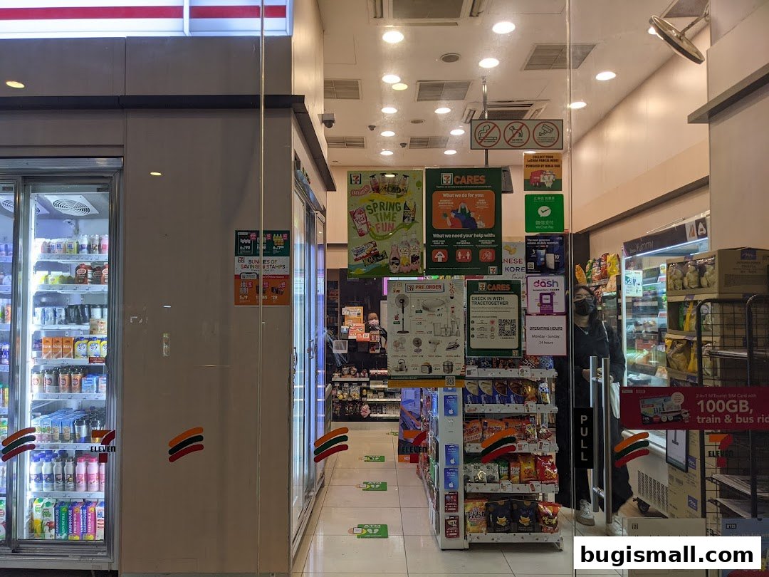 The entrance of a 7-Eleven convenience store, showcasing refrigerators and shelves stocked with products.