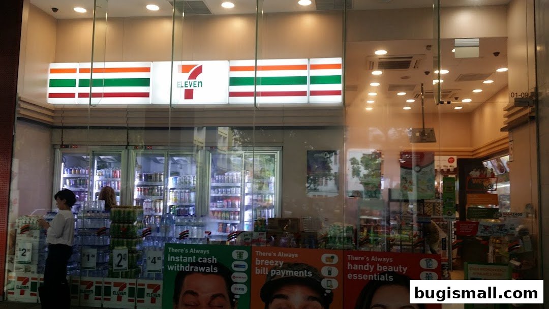 The exterior of a 7-Eleven convenience store with its iconic signage and displays of drinks and products.