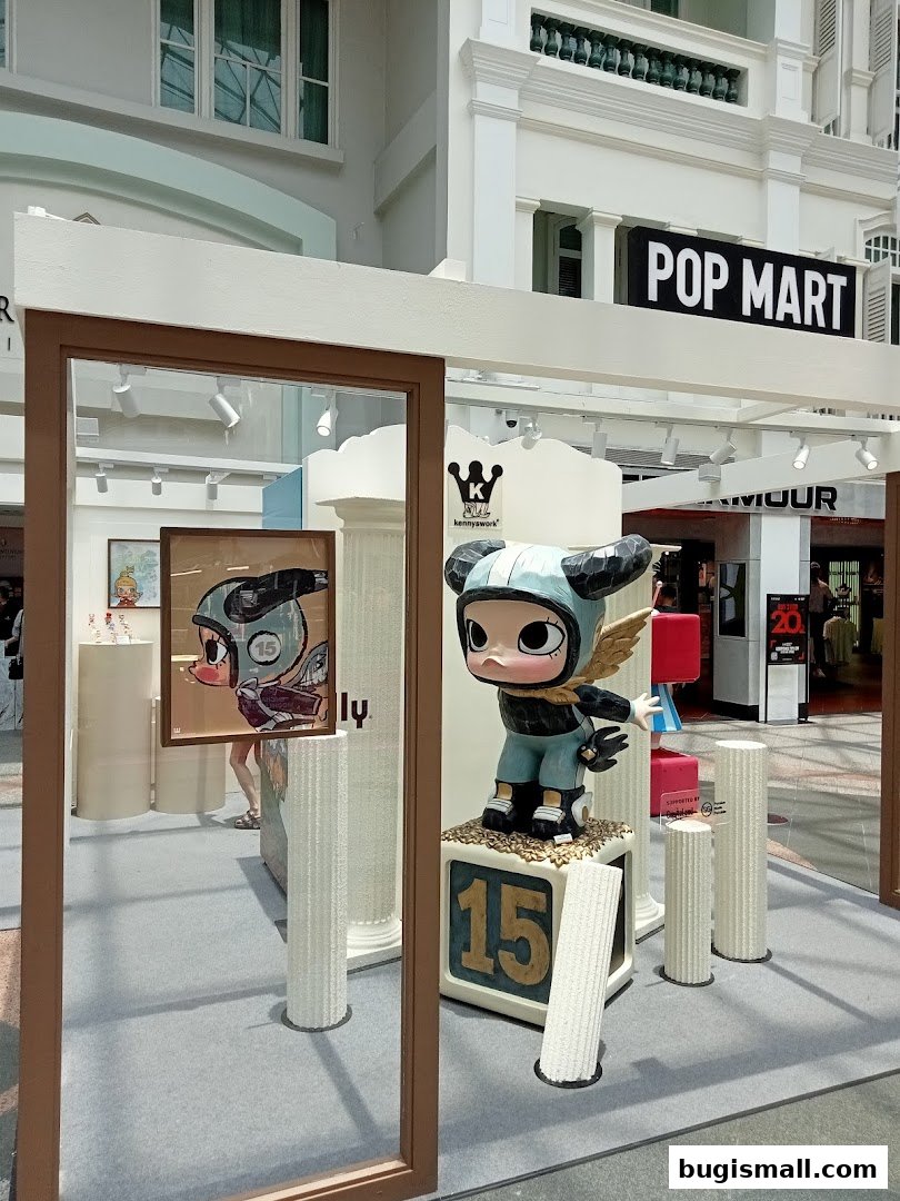 A display featuring a large figurine and artwork, with a POP MART sign visible.