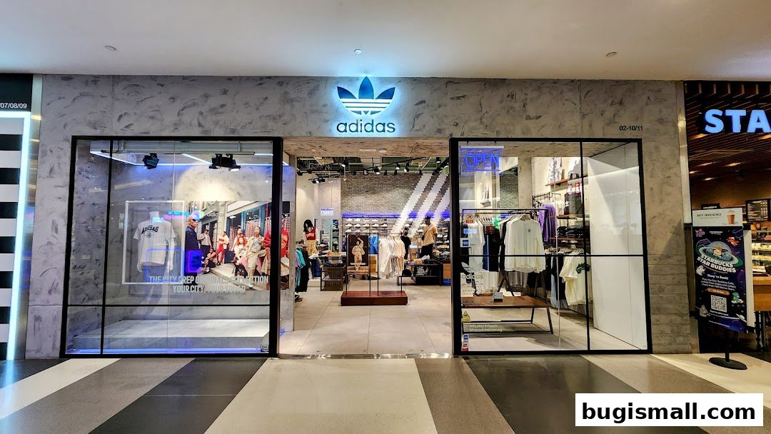 The entrance of an Adidas Originals store with clothing displays and mannequins visible inside.