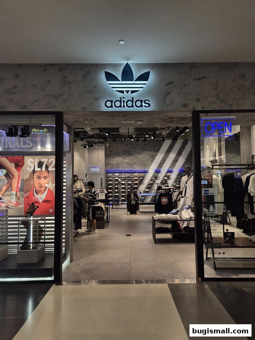 The entrance of an Adidas Originals store with the iconic logo and displays of merchandise.