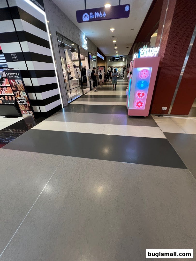 A shopping mall corridor with the Adidas Originals store and a cotton candy machine visible.