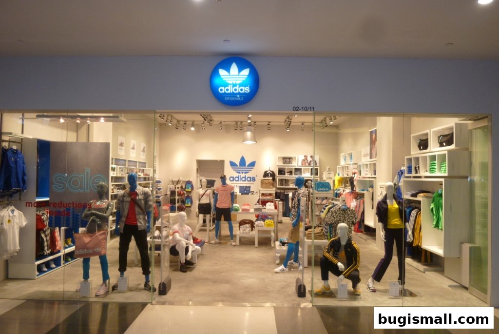 Adidas Originals store interior with mannequins displaying sportswear and a prominent Adidas logo.