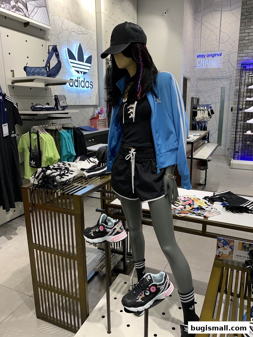 Mannequin wearing Adidas sportswear with Adidas logo and merchandise displayed.