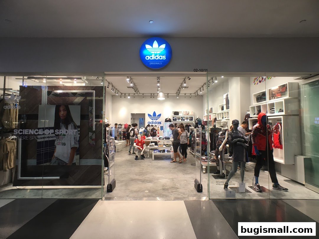 The entrance of an Adidas Originals store showcasing apparel and mannequins.