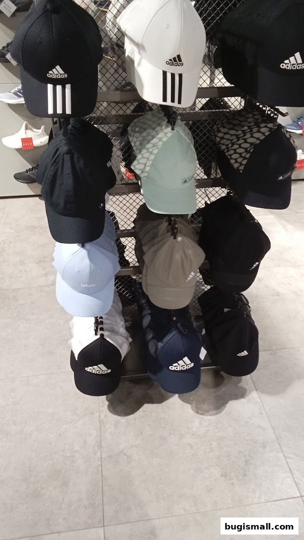 A display of various Adidas baseball caps in different colors and styles.