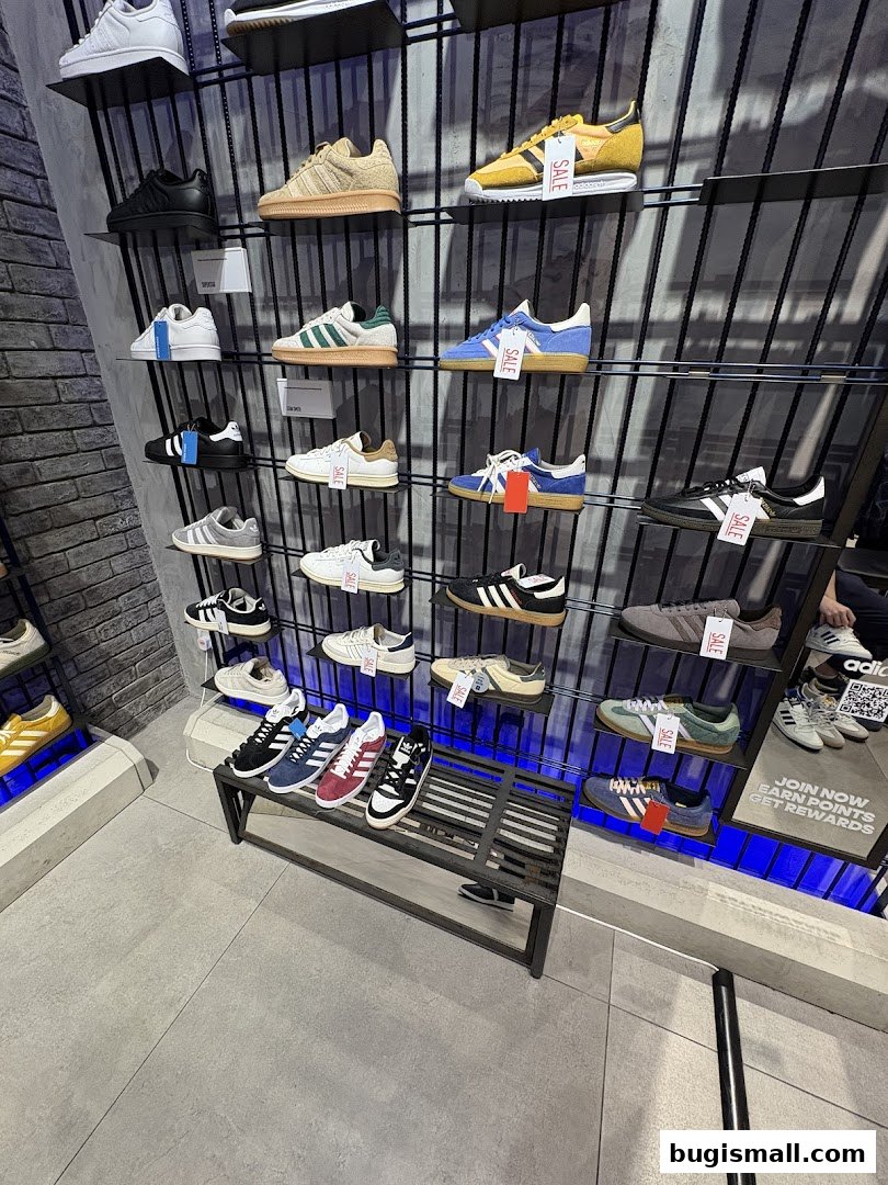 A display of various Adidas sneakers on shelves, with some marked as 'SALE'.