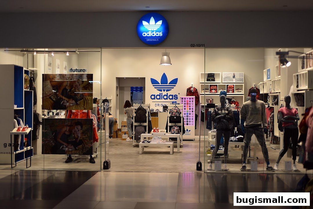 The entrance of an Adidas Originals store showcasing apparel and accessories on mannequins and shelves.