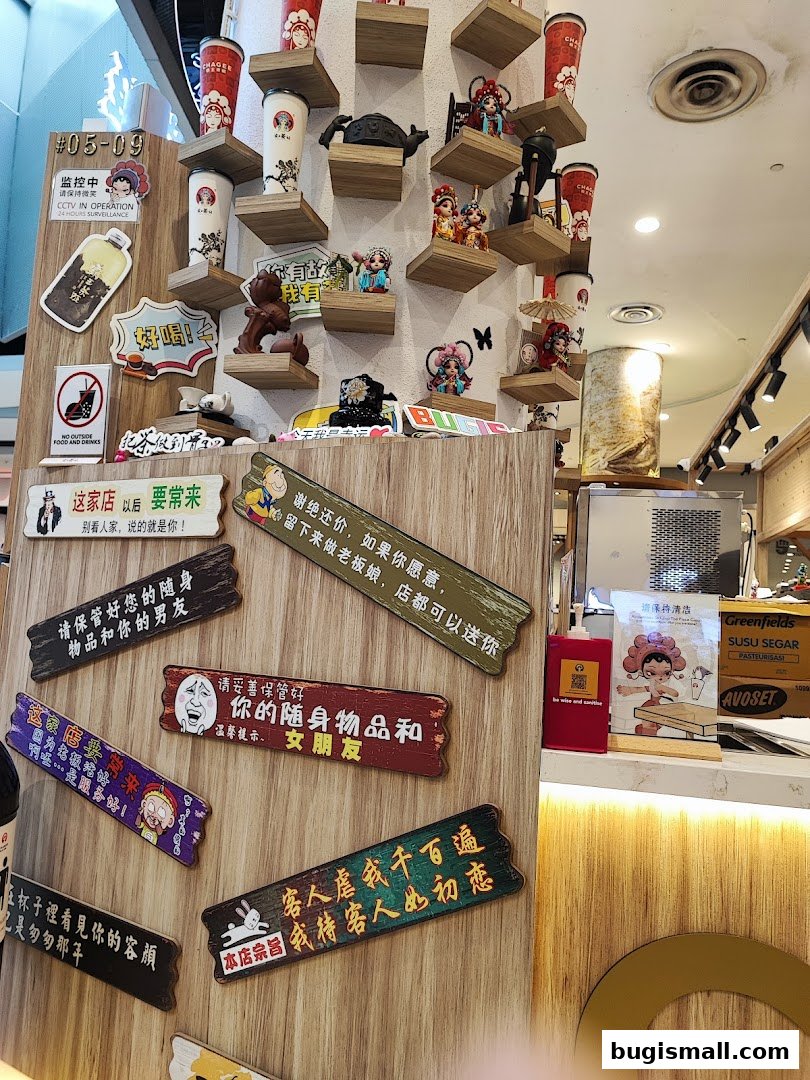 A wall decorated with various signs, cups, and figurines, with a counter and products visible in the background.