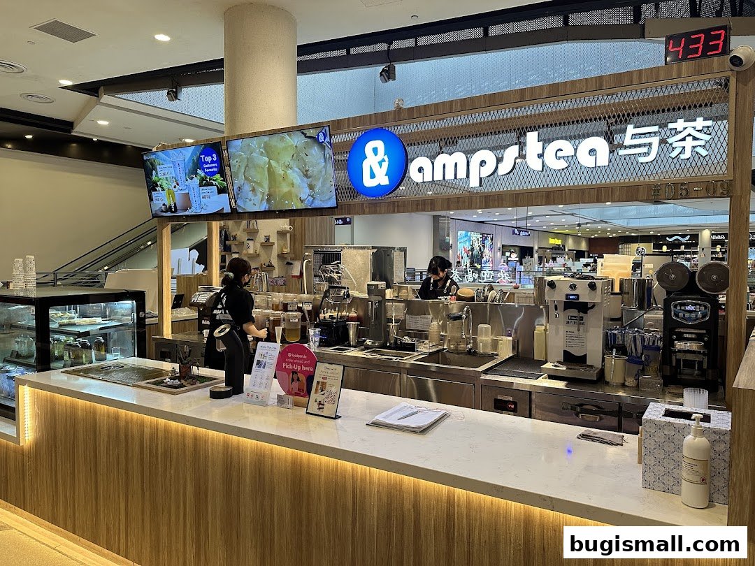 A modern tea shop counter with staff preparing drinks and digital displays.