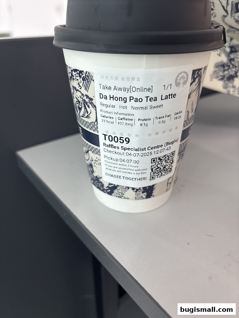 A close-up of a takeaway cup from Amps Tea with a Da Hong Pao Tea Latte.