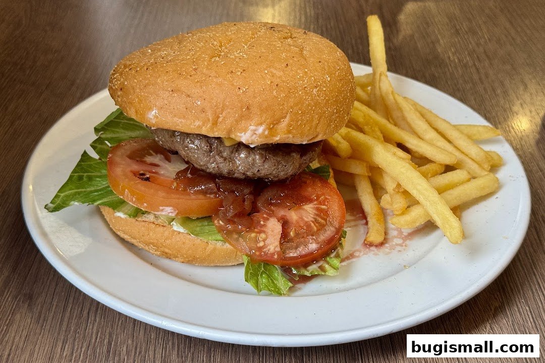 A juicy burger with fresh lettuce and tomato, served with a side of golden fries.