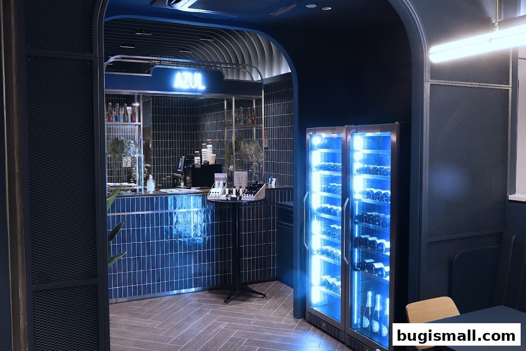 Interior view of AZUL GV Bugis, showcasing a modern bar area with blue tiled counter and a wine fridge.