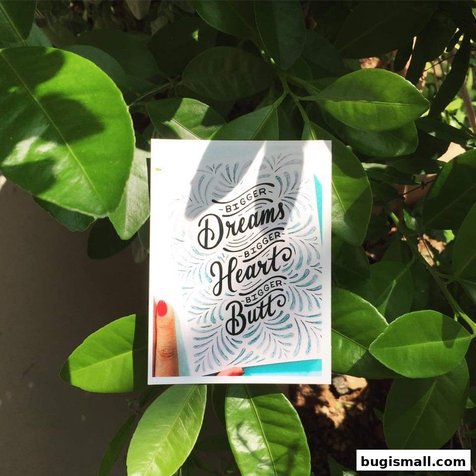 A card with hand-lettered text about dreams, heart, and butt surrounded by green leaves.
