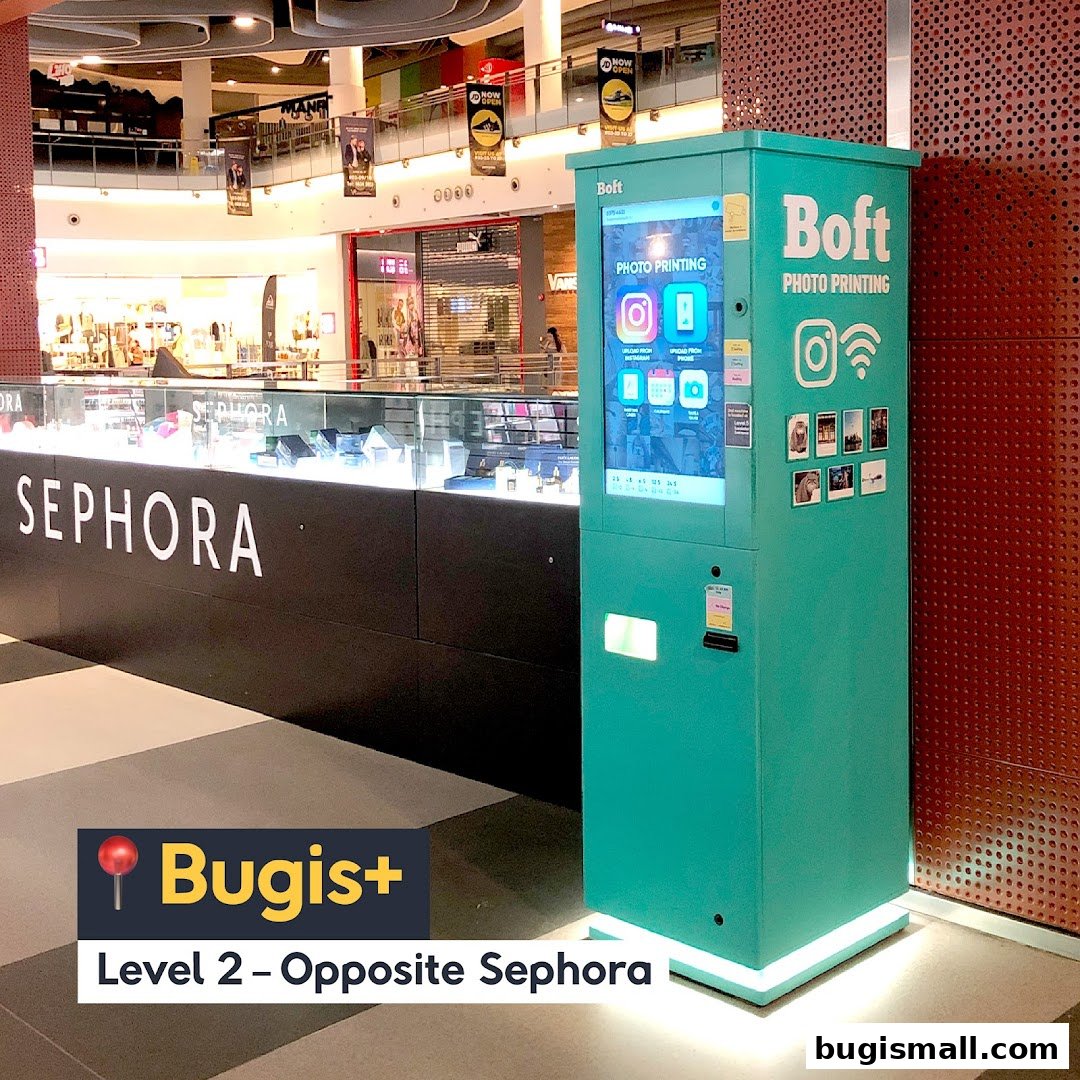 A teal photo printing machine by Boft is located in a shopping mall, opposite Sephora.