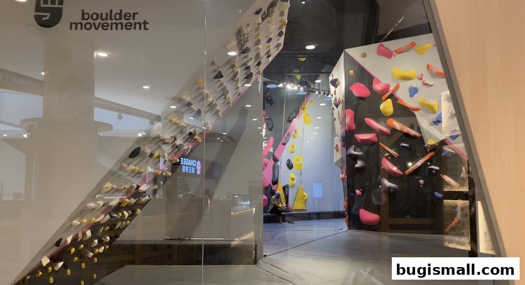 Entrance to Boulder Movement, a climbing gym with colorful holds on angled walls.