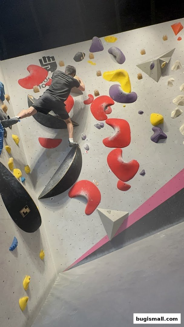 A person bouldering on a colorful climbing wall with various holds.