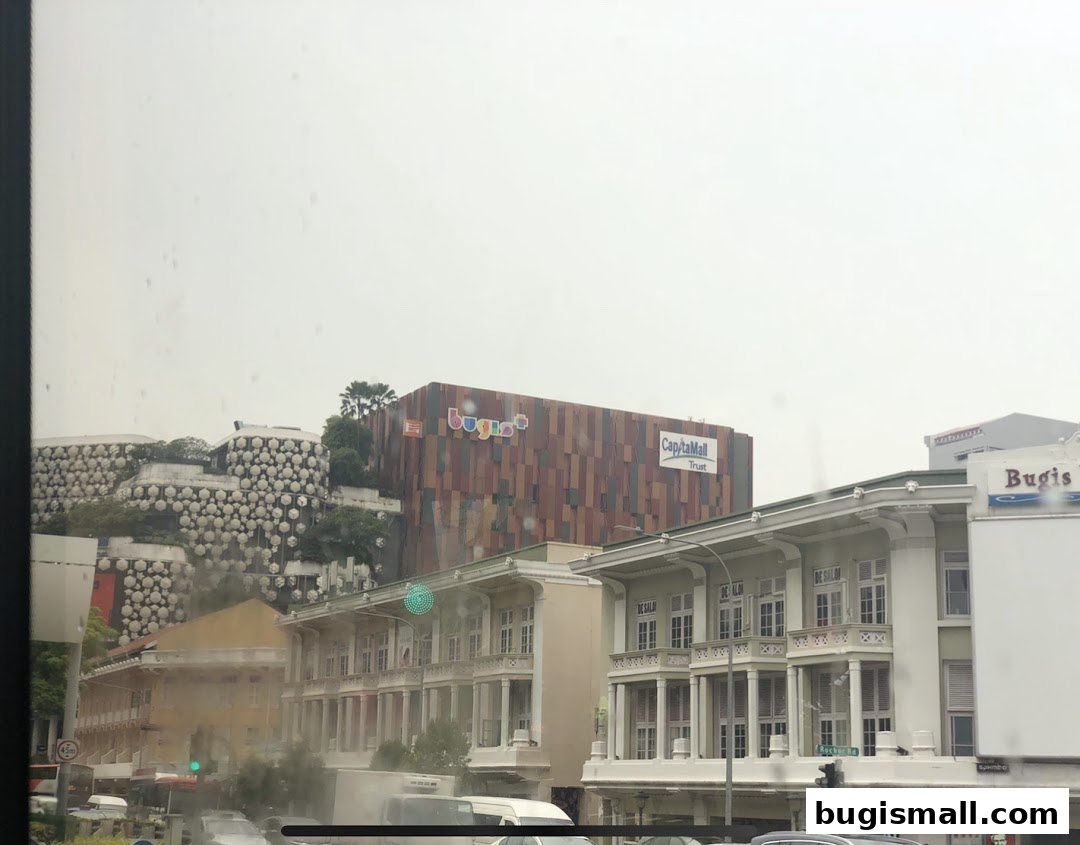 A view of the Bugis streetscape featuring the CapitaMall Trust building and other shops.