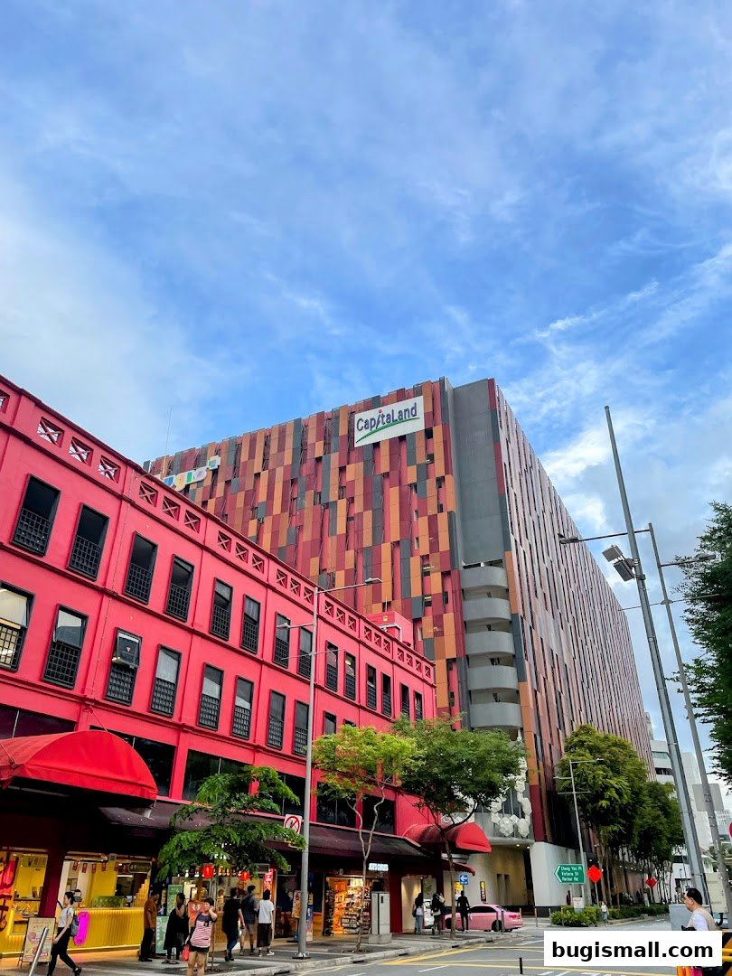 A street view of the CapitaLand building with colorful facade and adjacent red buildings.