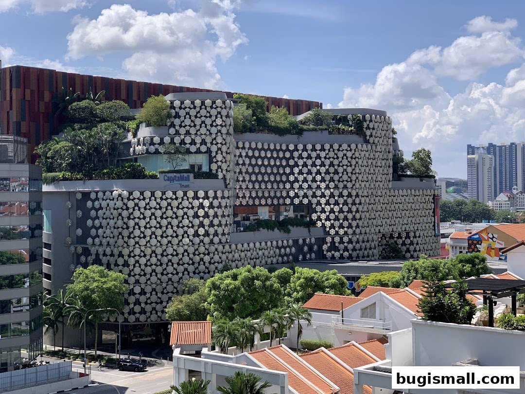 A modern building with unique hexagonal facade and lush greenery on multiple levels.