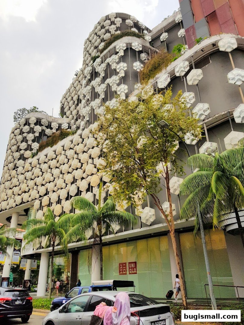 A modern building with a unique facade, featuring a UNIQLO store on the ground floor.
