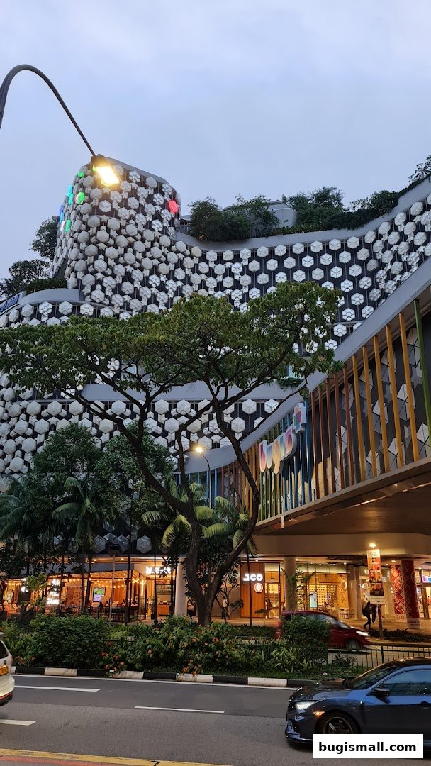 Exterior view of a modern building with unique hexagonal facade and lush greenery.