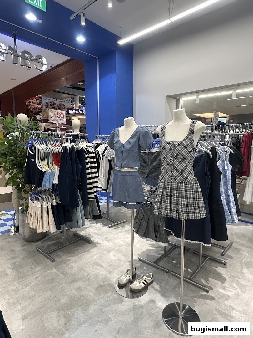 Mannequins display trendy outfits in a brightly lit clothing store.