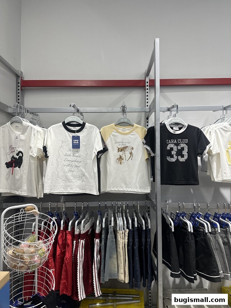 A display of t-shirts and shorts from Cara Club, featuring various graphic designs and colors.