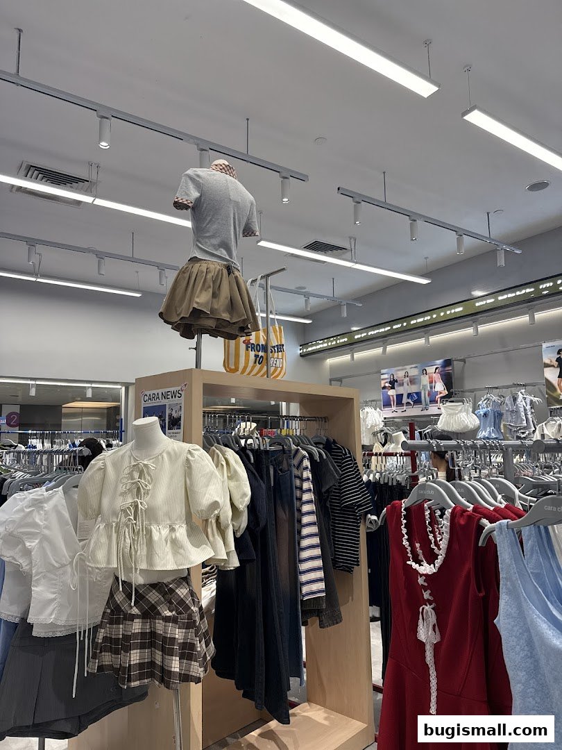 Mannequins display trendy outfits in a well-lit clothing store.