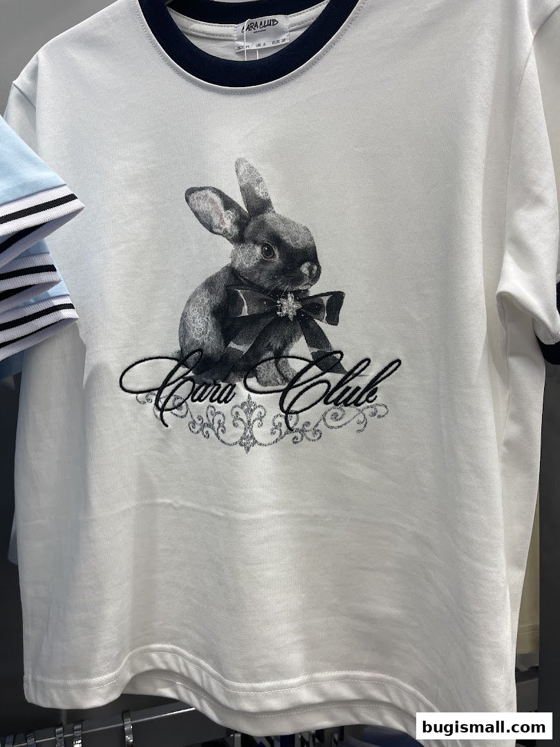 A white t-shirt with a graphic of a rabbit wearing a bow and the text 'Cara Club'.