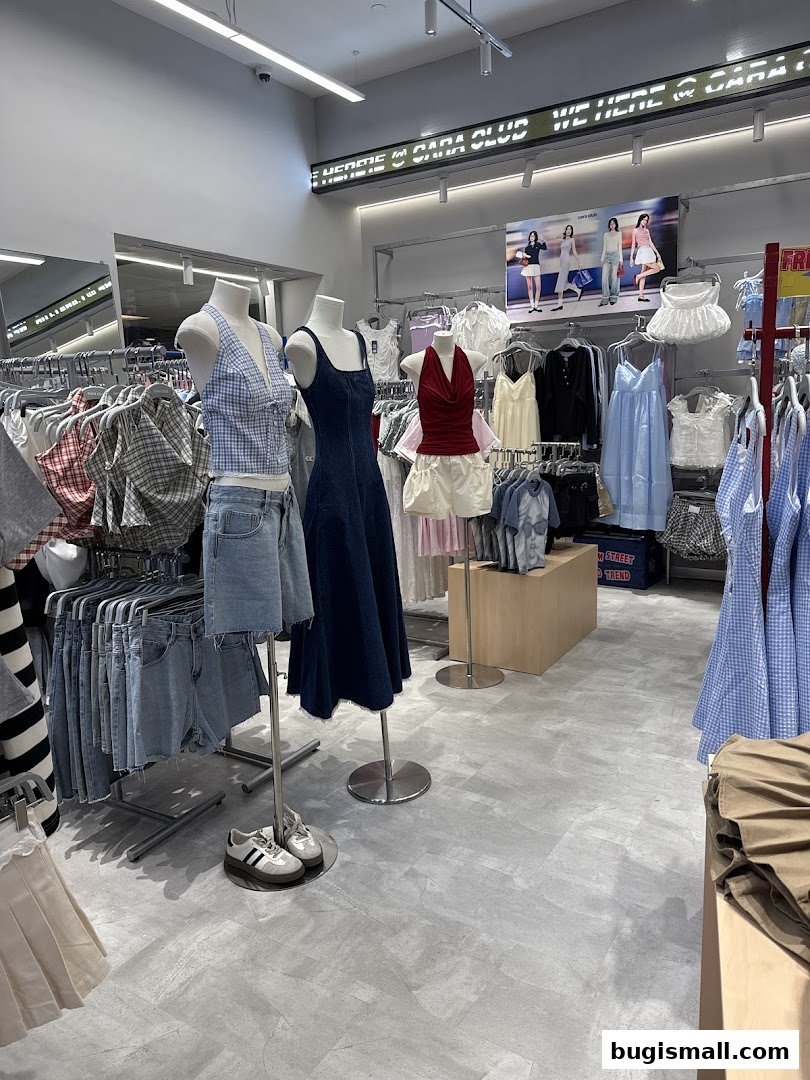 Interior view of a clothing store with mannequins displaying outfits and racks of apparel.