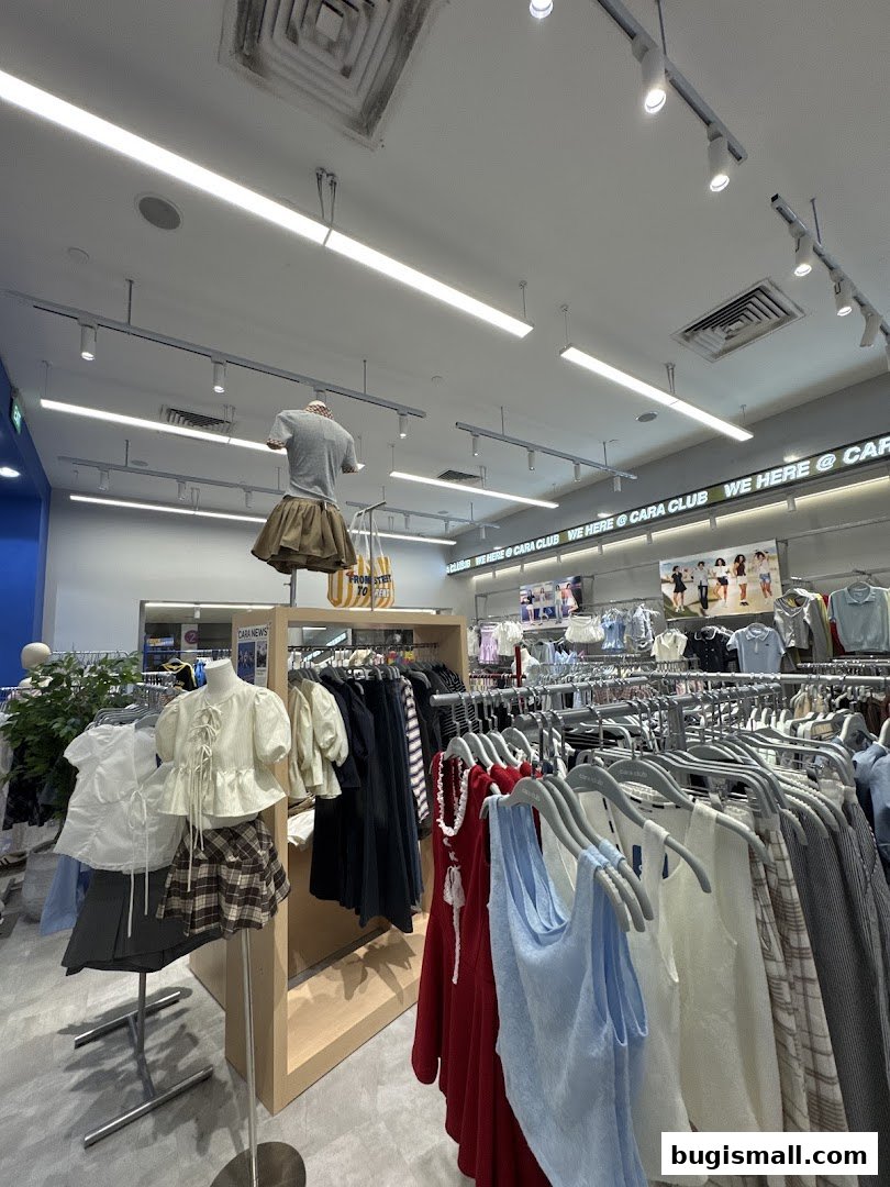 Interior view of a clothing store with racks of apparel and mannequins.