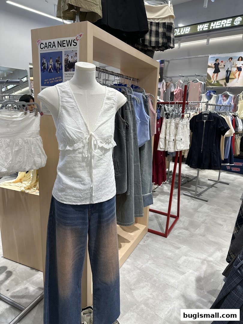 Mannequin wearing a white top and gradient jeans, surrounded by racks of trendy clothing.