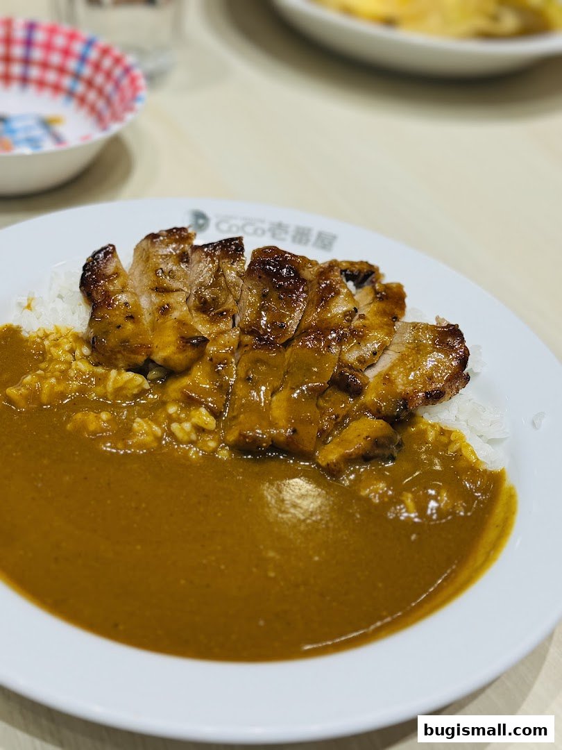 A close-up of a delicious Japanese curry with grilled pork and rice.