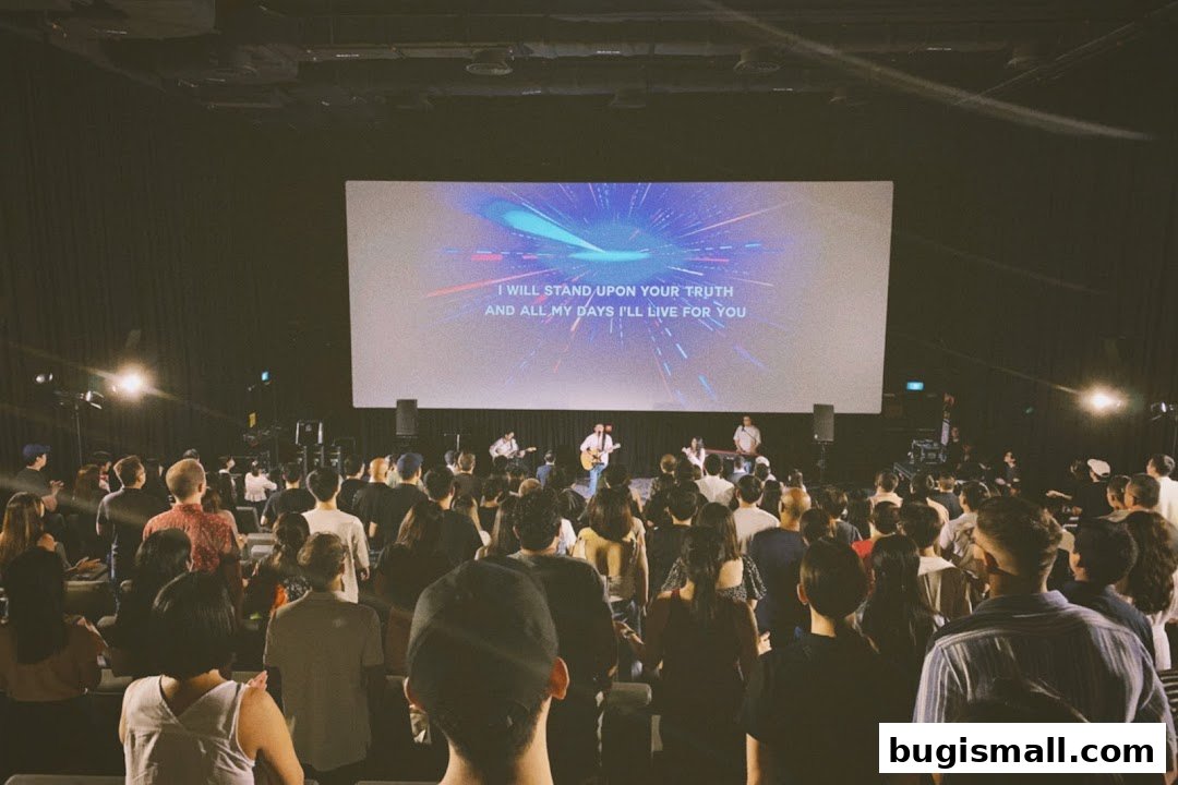 A large audience watches a performance on a screen with lyrics at Cornerstone Community Church.