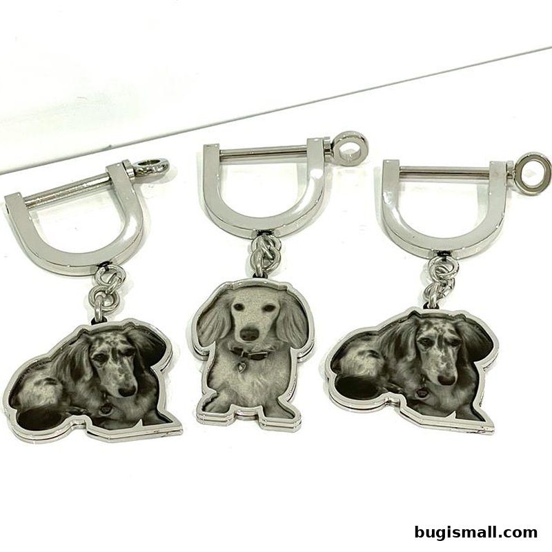 Three silver keychains featuring dachshund dog portraits on a white background.