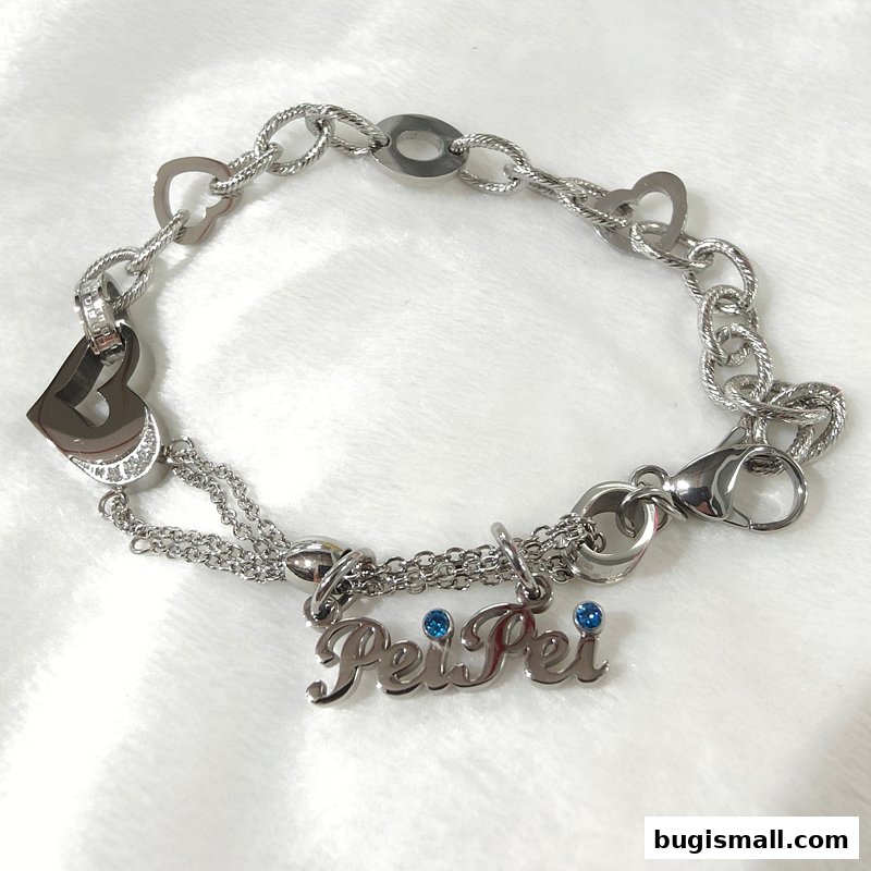 A silver bracelet with heart charms and a 'Pei Pei' nameplate with blue stones.