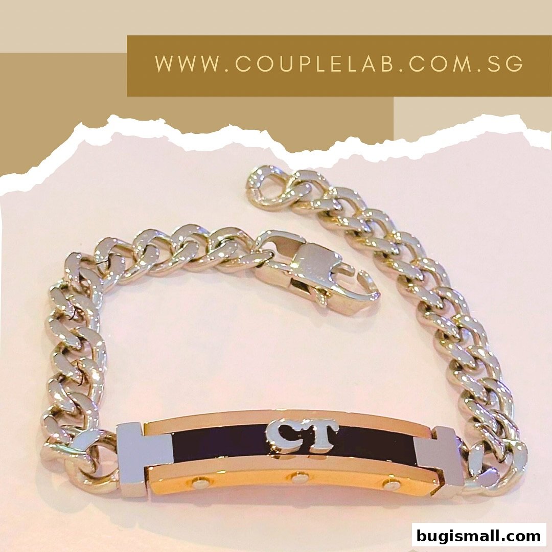A close-up shot of a silver and gold bracelet with the initials 'CT' engraved on it.