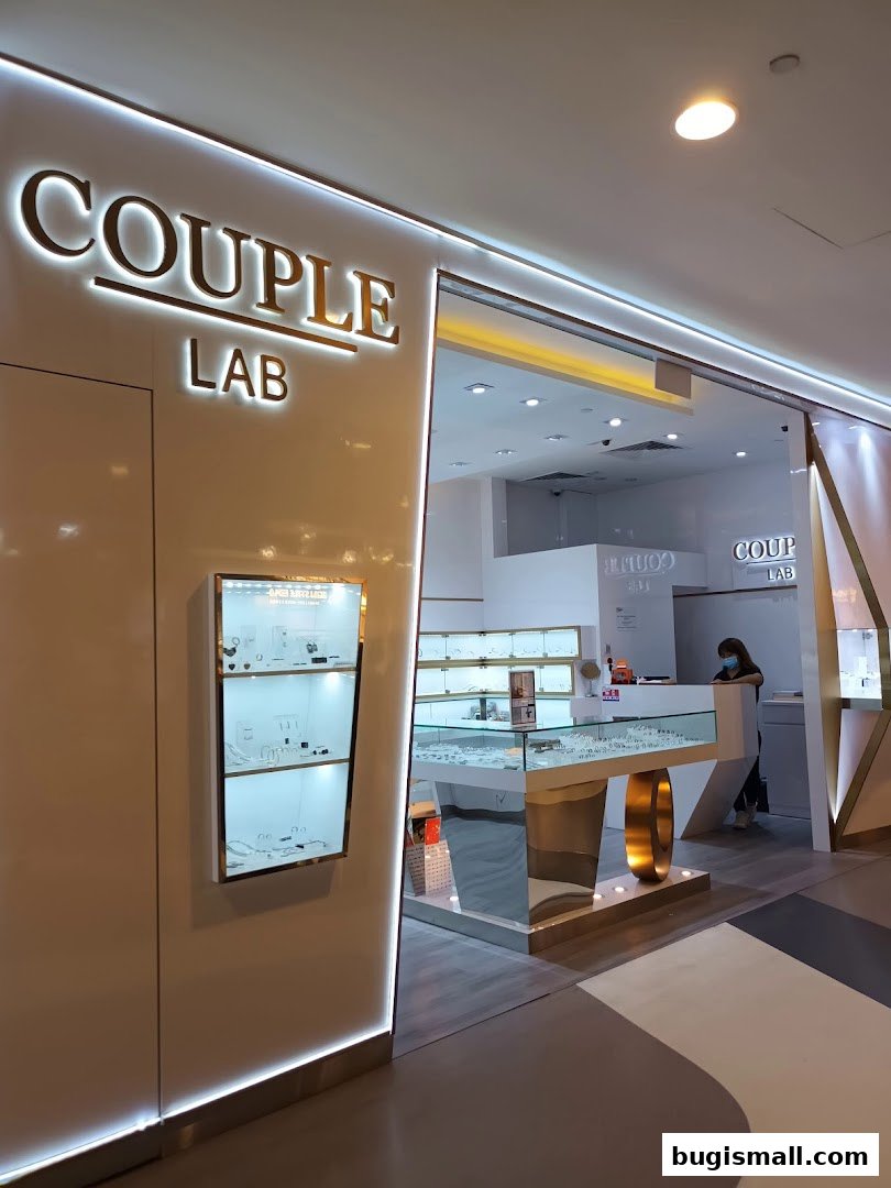 The entrance of Couple Lab, a jewelry store, with illuminated signage and display cases.