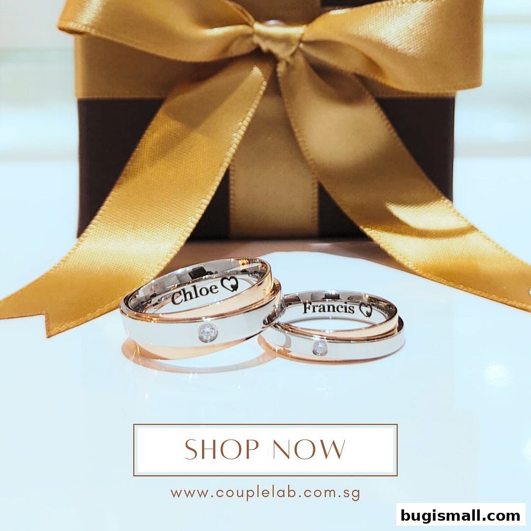 Two personalized wedding rings with a gift box and ribbon.