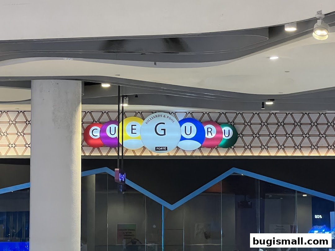 The 'Cue Guru' shop sign features colorful billiard balls spelling out the name.
