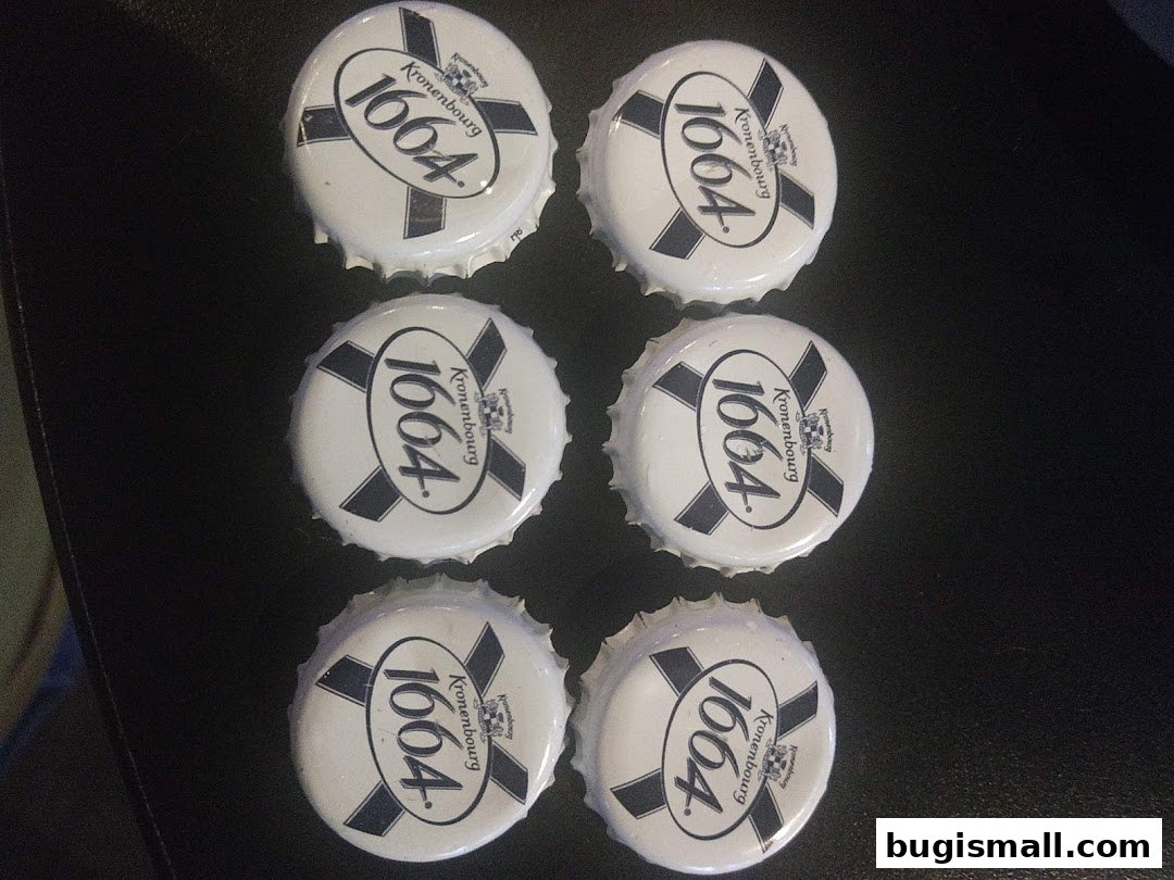 Six Kronenbourg 1664 beer bottle caps arranged in two columns on a dark surface.
