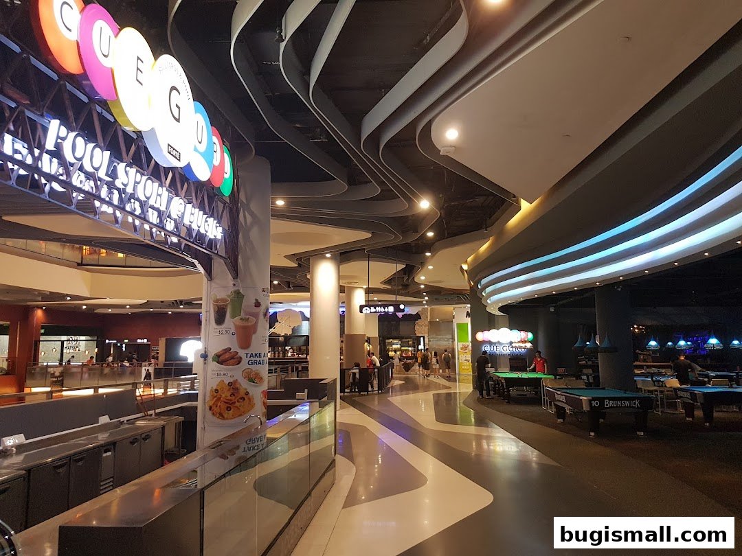 Interior view of Cue Guru, a pool sports and entertainment venue with a bar and seating.