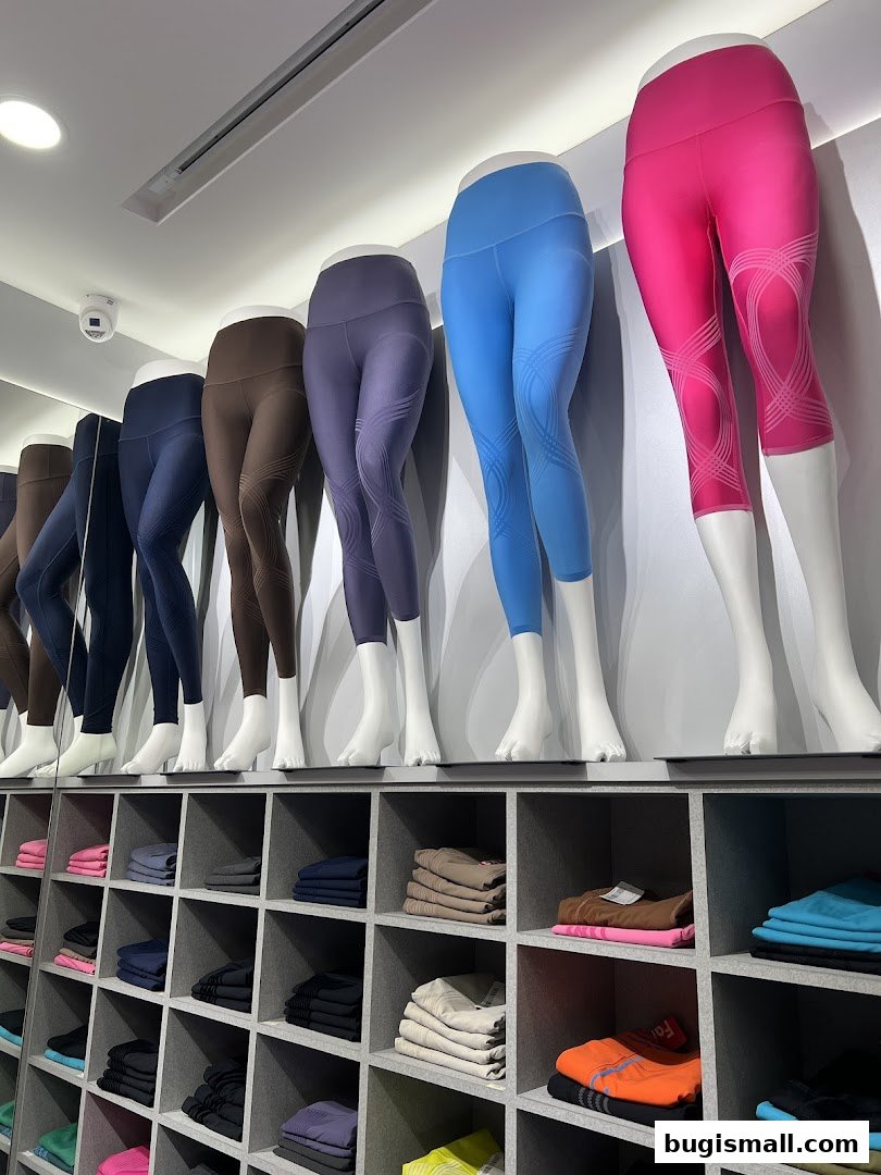 Mannequins display colorful athletic leggings above shelves stocked with folded apparel.