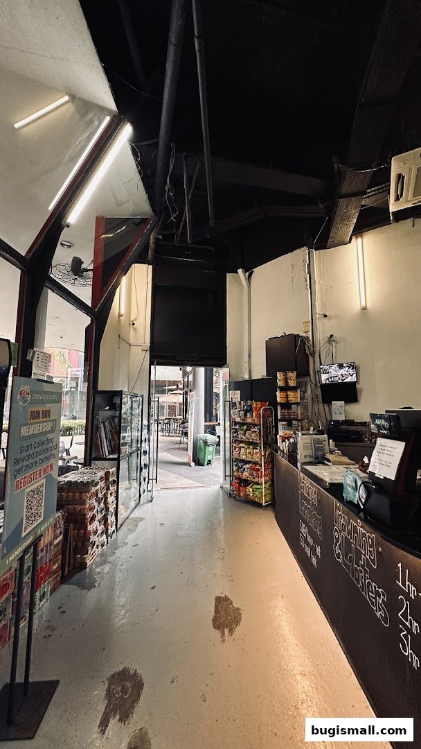 Interior view of a shop with shelves of snacks, a counter, and an entrance to an outdoor seating area.