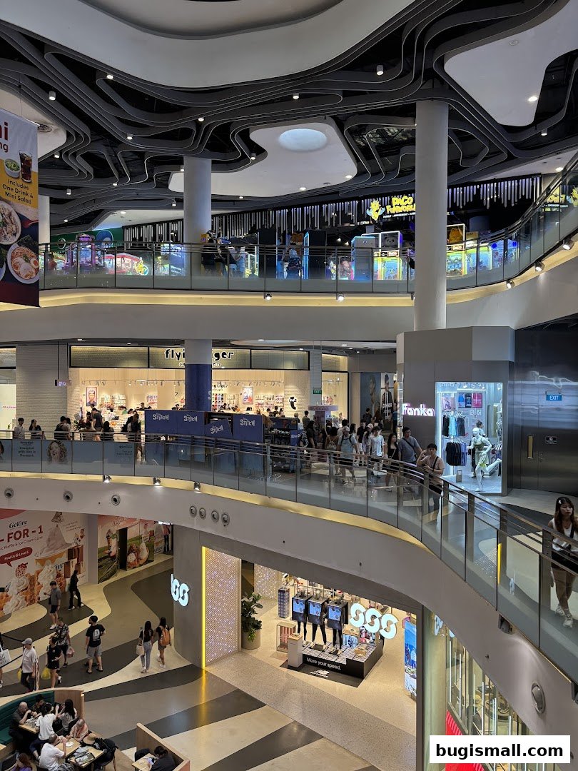 A multi-level shopping mall interior with various shops and escalators.