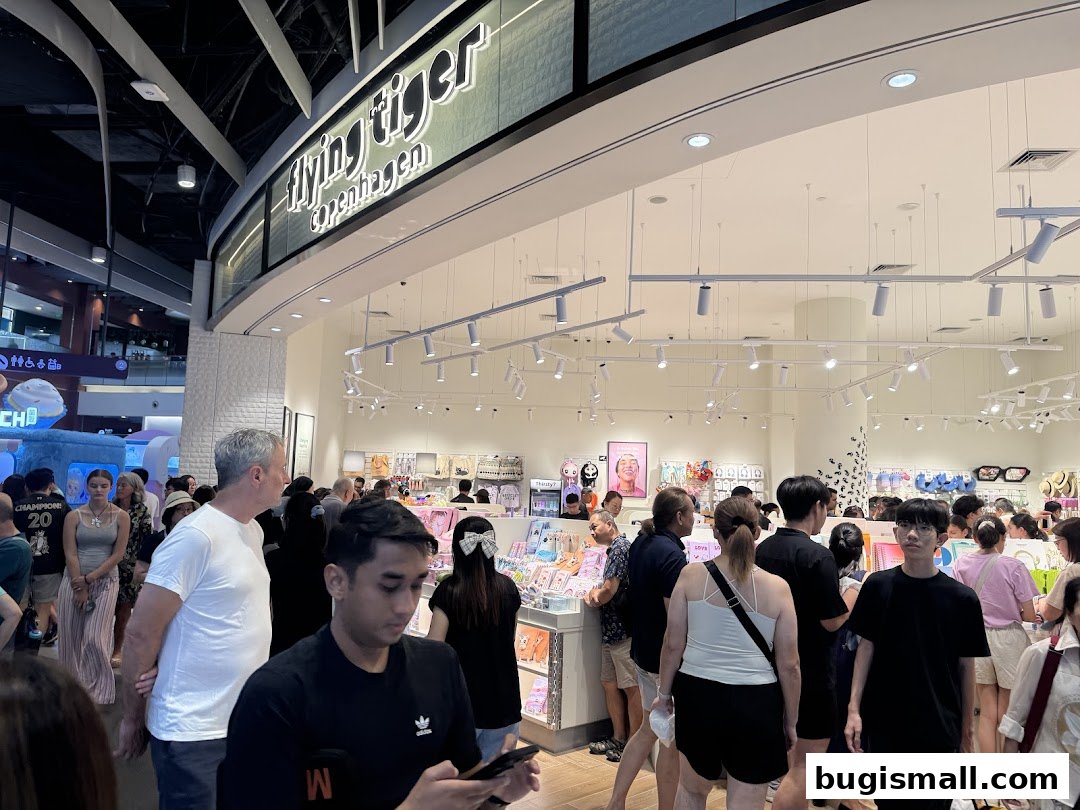 People browsing inside a brightly lit Flying Tiger Copenhagen store with many products on display.