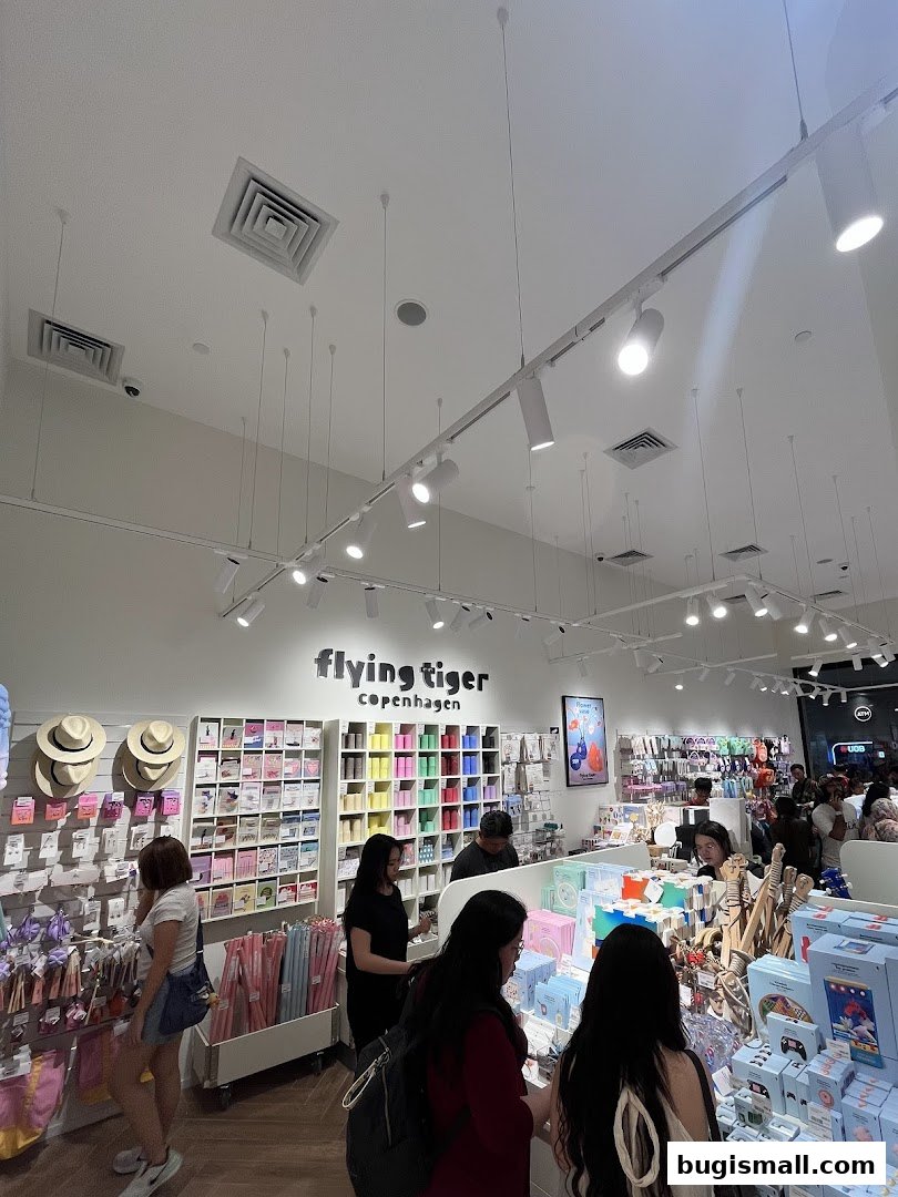 Interior view of a Flying Tiger Copenhagen shop with customers browsing colorful merchandise.