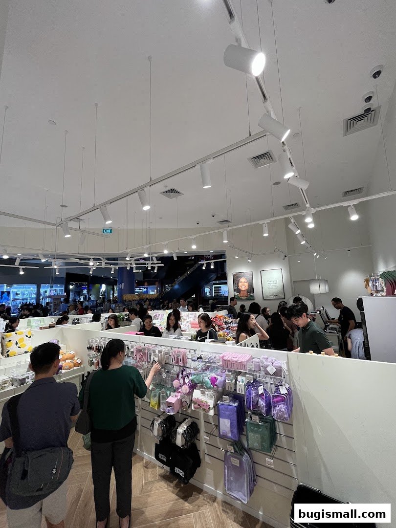 Busy interior of Flying Tiger Copenhagen with shoppers browsing colorful merchandise.